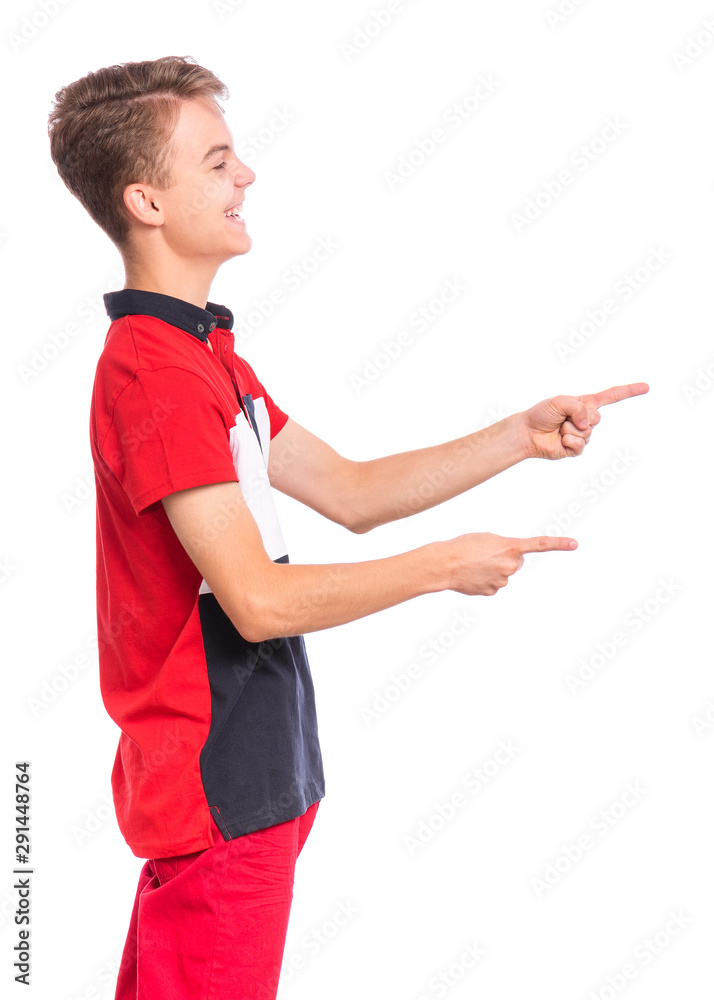 Excited teen boy pointing fingers away at copyspace - side view, isolated on white background. Cute teenager smiling and laughing pointing fingers at something. Happy child looking away - profile. Excited teen boy pointing fingers away at copyspace - side view, isolated on white background. Cute teenager smiling and laughing pointing fingers at something. Happy child looking away - profile.