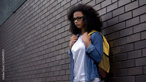 Lonely afro-american schoolgirl standing college backyard, puberty insecurities