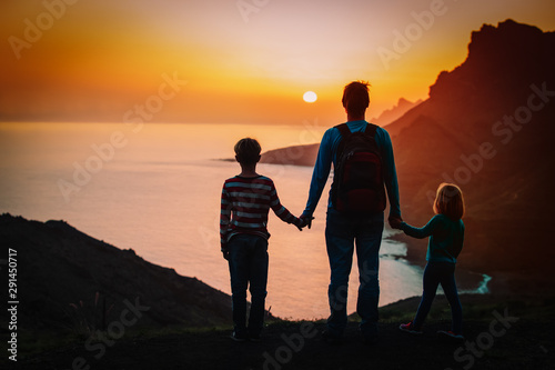 father with kids-boy and girl- travel in sunset mountains, family travel