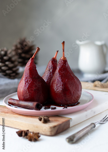 Red wine poached pears in white plate, delicious winter french dessert, copy space