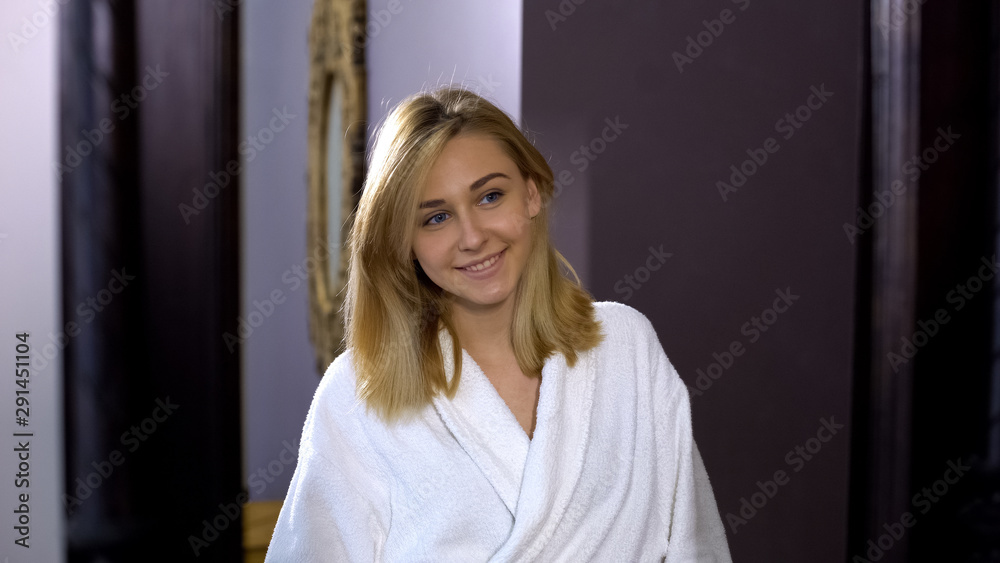 Fototapeta premium Pretty woman looking at mirror reflection and smiling, positive mood for day