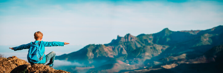 happy boy hiking in mountains, family travel concept