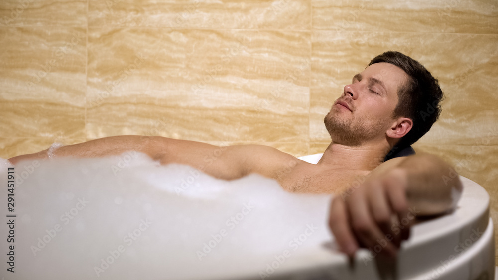 Handsome man enjoying aroma and hot water, taking bath with foam, leisure Handsome man enjoying aroma and hot water, taking bath with foam, leisure