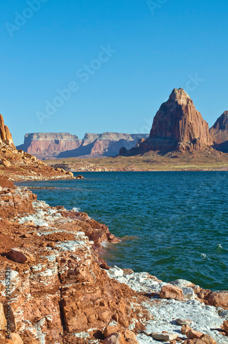 The red rock canyon cliff towers in the warm water and dusk sunlight