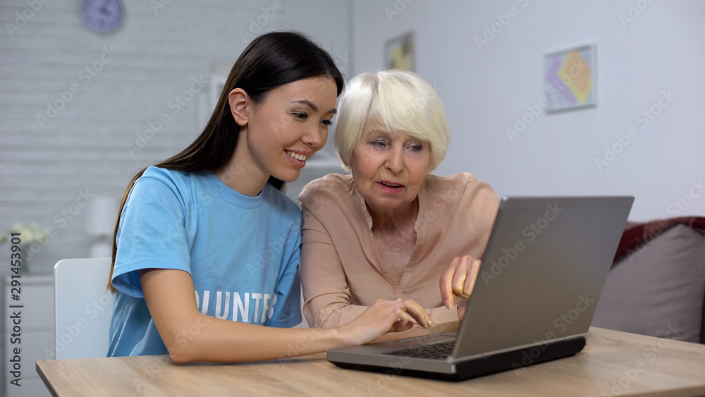 Social activist and senior woman watching photos on laptop, spending free time Social activist and senior woman watching photos on laptop, spending free time
