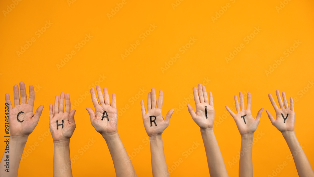 Charity written palms on orange background, donation center, volunteer project