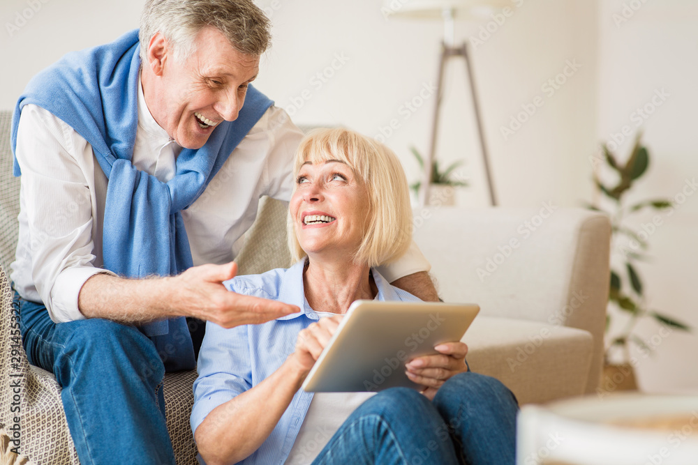 Shopping online. Happy elderly couple using tablet Shopping online. Happy elderly couple using tablet