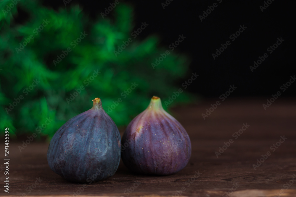 Fototapeta premium Fig fruits. Still life of figs on a dark wooden table.