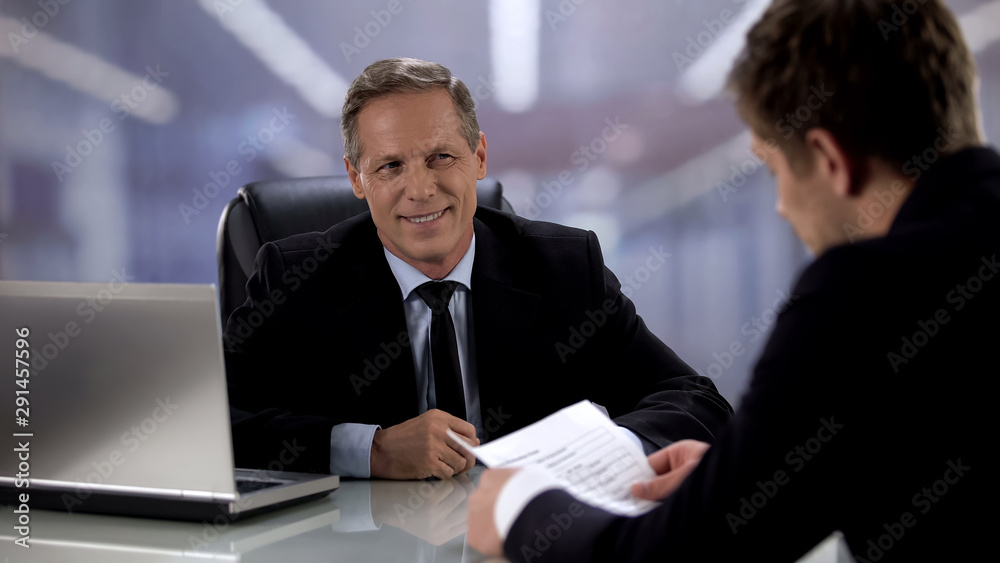 Optimistic male boss smiling to candidate during job interview, good result Optimistic male boss smiling to candidate during job interview, good result