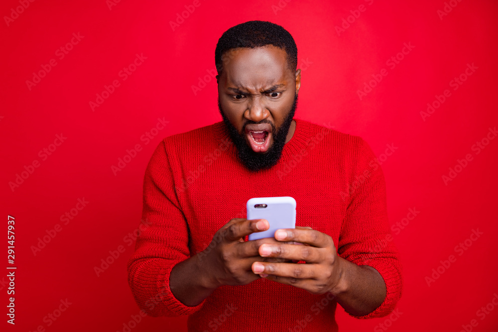 Close-up portrait of his he nice attractive irritated annoyed outraged bearded guy using wireless connection app 5g blog post smm spam messenger isolated over bright vivid shine red background Close-up portrait of his he nice attractive irritated annoyed outraged bearded guy using wireless connection app 5g blog post smm spam messenger isolated over bright vivid shine red background