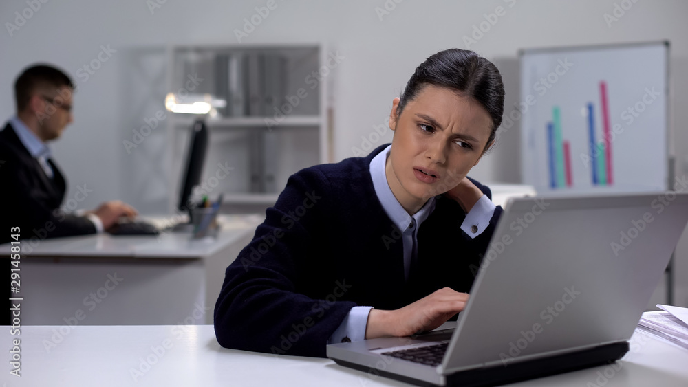 Female manager working on laptop in office feeling neck pain, sedentary life Female manager working on laptop in office feeling neck pain, sedentary life