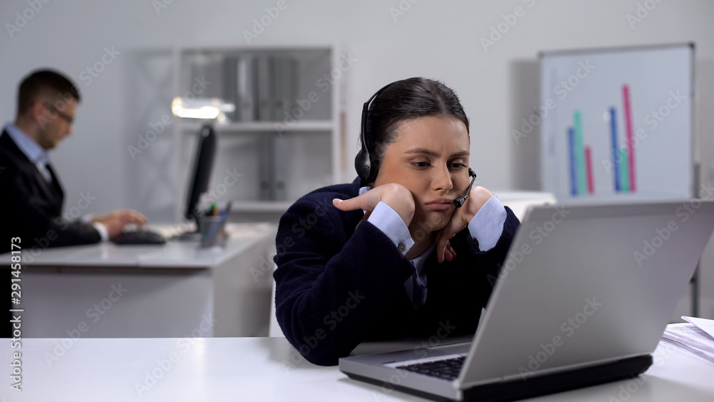 Bored operator in headset at workplace waiting for customer call, telemarketing Bored operator in headset at workplace waiting for customer call, telemarketing