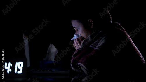 Technical support female worker suffering cold and sneezing, working at home © motortion