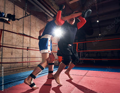 strong male sportsmen fighter exercising mma with his trainer in the ring at the health club