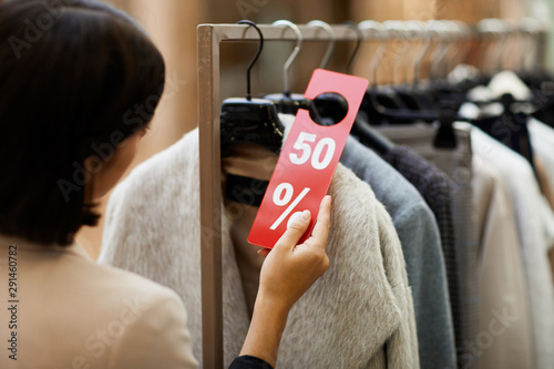 Bild auf Leinwand Unrecognizable young woman choosing winter clothes on sale in shopping mall, cop