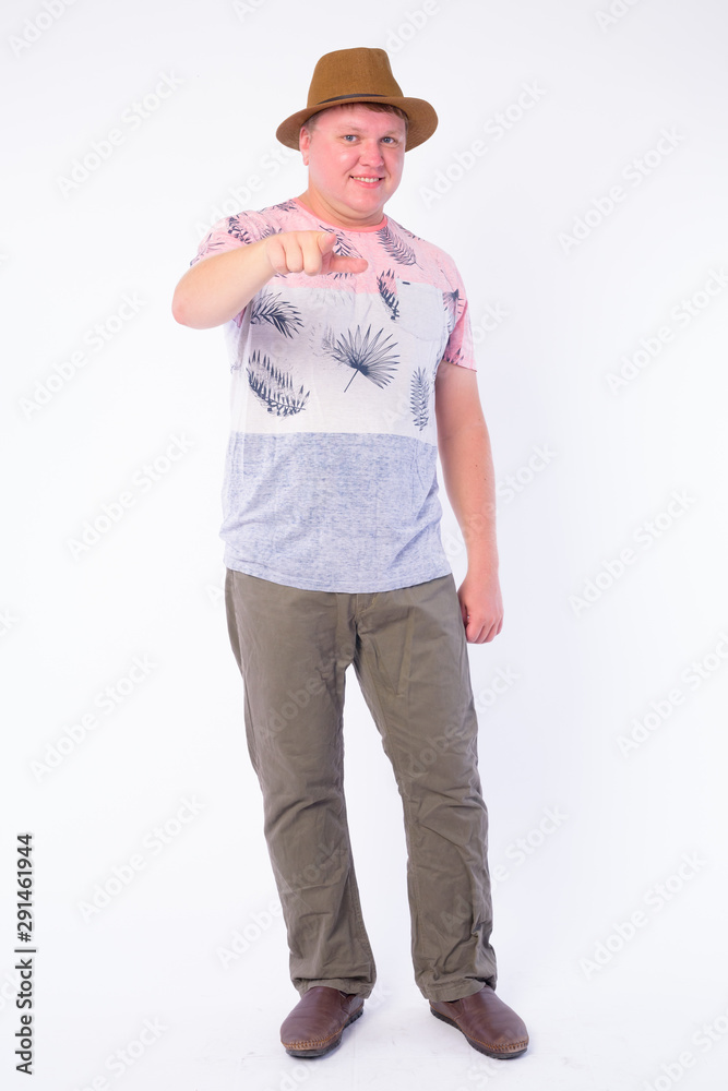 Full body shot of happy overweight tourist man pointing at camera Full body shot of happy overweight tourist man pointing at camera