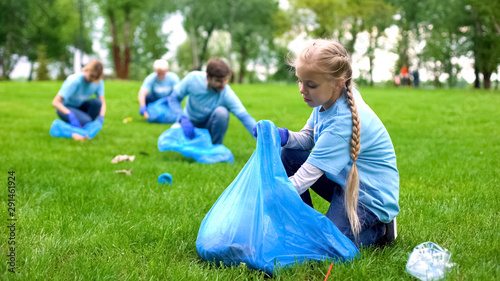 School girl with group of eco volunteers picking up litter park, saving nature #291461924