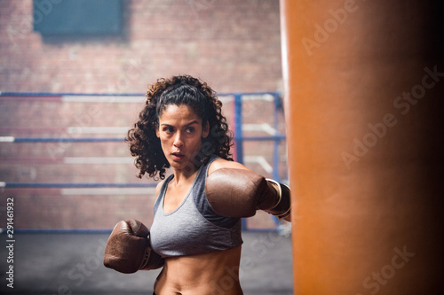 Female boxer punching a punch bag photo