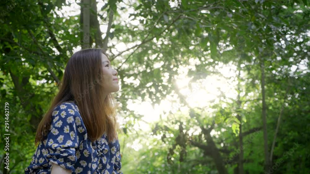 Woman smiling enjoying relaxing, feeling alive, breathing fresh air, got freedom from work or relations, calm and dreaming in green park Woman smiling enjoying relaxing, feeling alive, breathing fresh air, got freedom from work or relations, calm and dreaming in green park