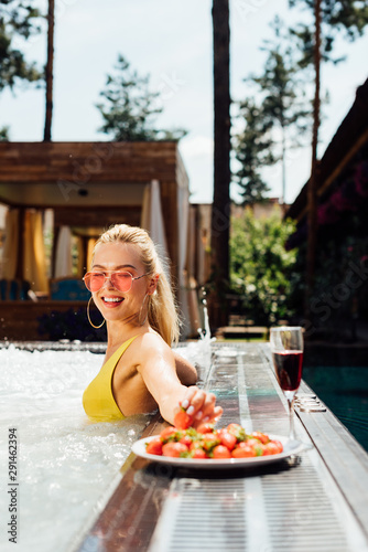 sexy girl in swimsuit with red wine and strawberries in swimming pool © LIGHTFIELD STUDIOS