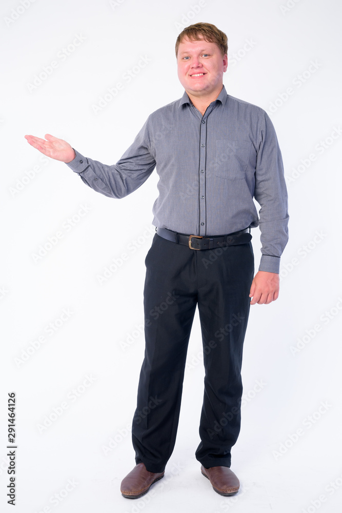 Full body shot of happy overweight businessman showing something Full body shot of happy overweight businessman showing something