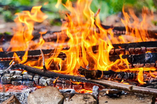 bonfire burns in a meadow, rural landscape