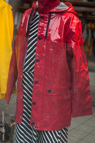 Closeup of red rain coats on hanger in fashion store showroom
