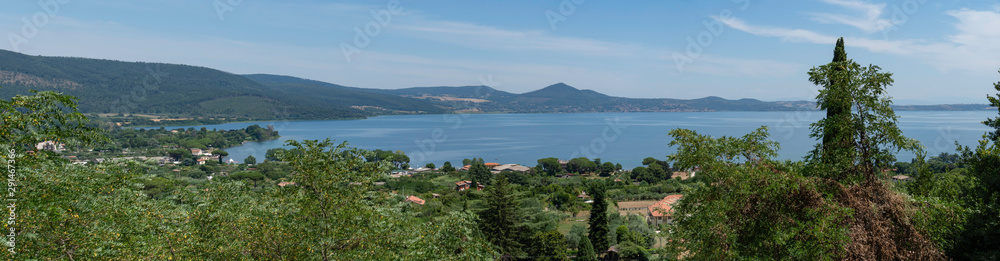 Lake of Bracciano  outside Rome, Italy, with green nature around water and blue sky.