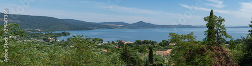 Lake of Bracciano outside Rome, Italy, with green nature around water and blue sky.