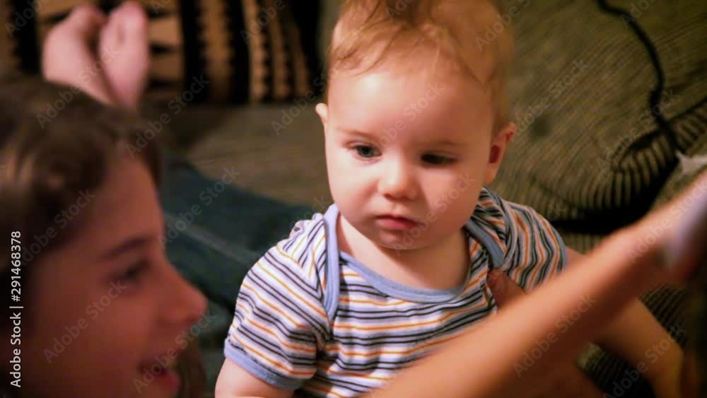 Young girl messes with the faces of her baby brother and her father