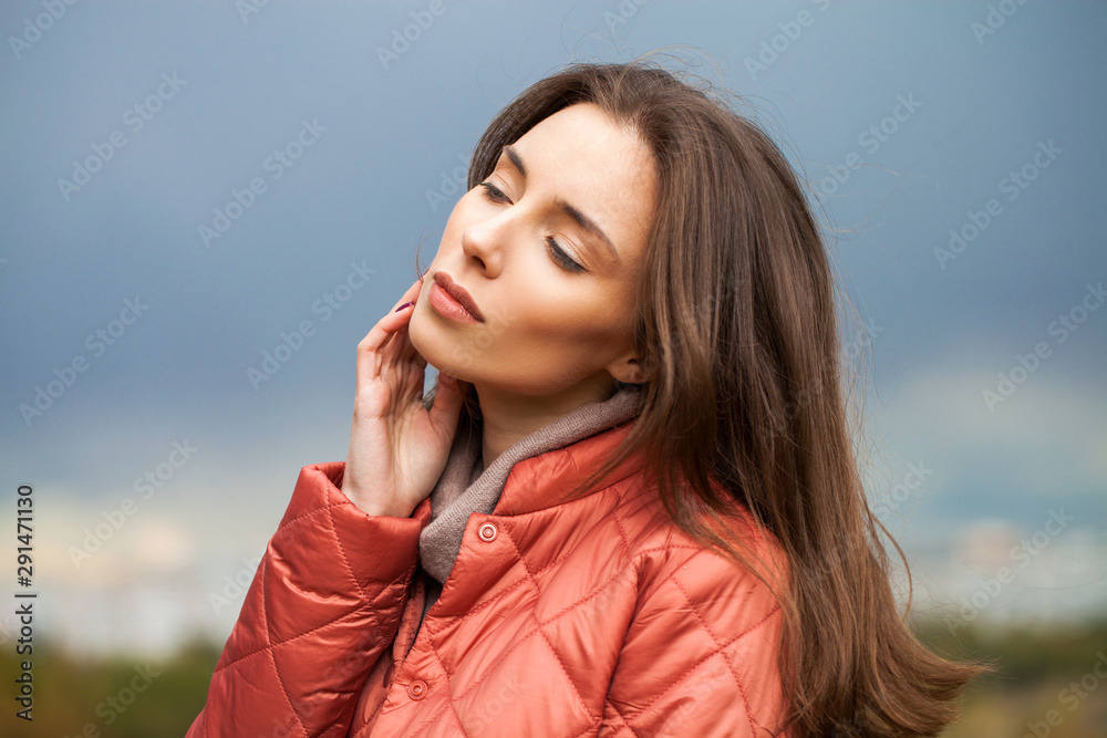 Portrait of a young beautiful woman in a pink jacket