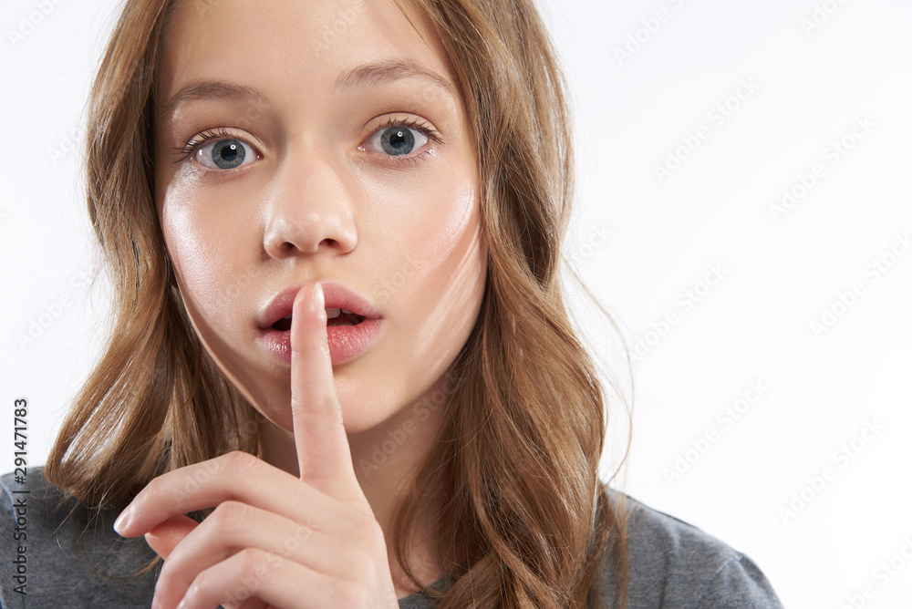 Charming teen girl keeping finger on slightly open lips Charming teen girl keeping finger on slightly open lips