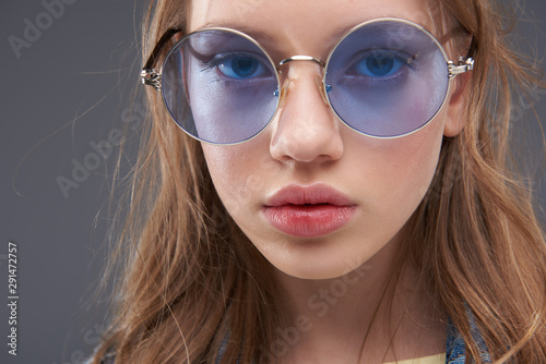 Charming teenage girl wearing blue round glasses