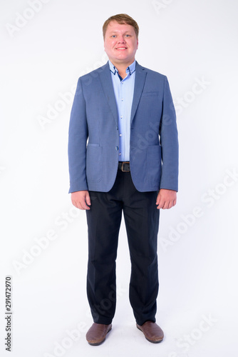 Full body shot of happy overweight businessman in suit smiling
