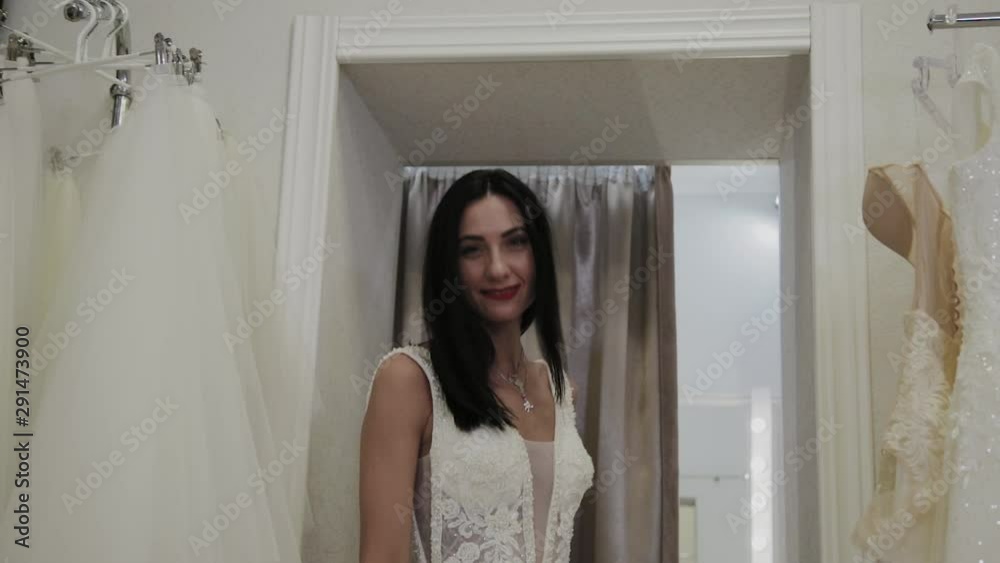 Beautiful girl measures a wedding dress in a bridal salon. Beautiful girl measures a wedding dress in a bridal salon.
