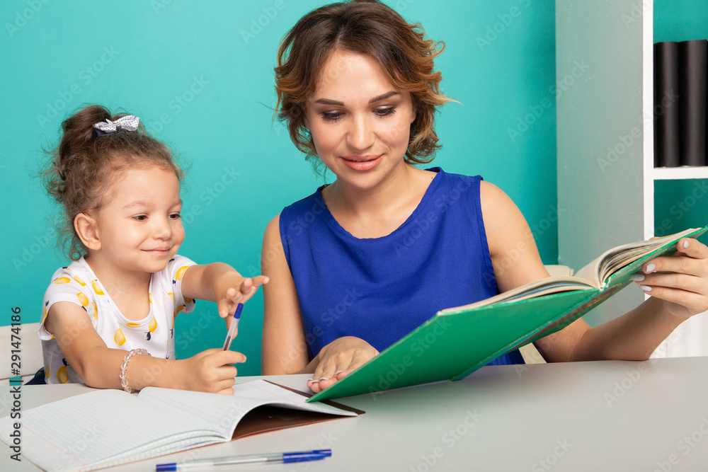 Young teacher in the classroom with little girl. Tutoring concept Young teacher in the classroom with little girl. Tutoring concept