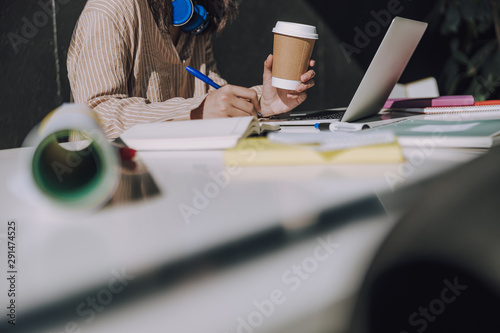 Young woman drinking tea in office indoors