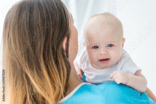 back view of young mother holding her child in hospital