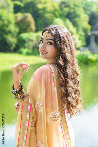 Indian woman in traditional saree looks back and smilingg