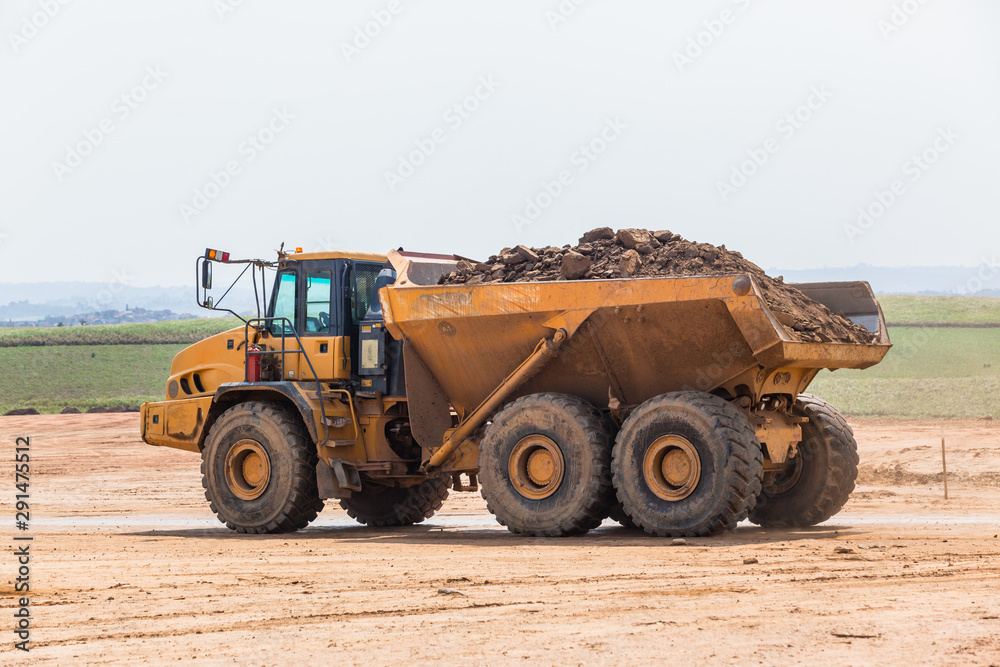 Industrial Dump Truck Vehicle Moving Earth Property Development Countryside Landscape. Industrial Dump Truck Vehicle Moving Earth Property Development Countryside Landscape.