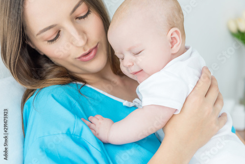 attractive and young mother holding her child in hospital