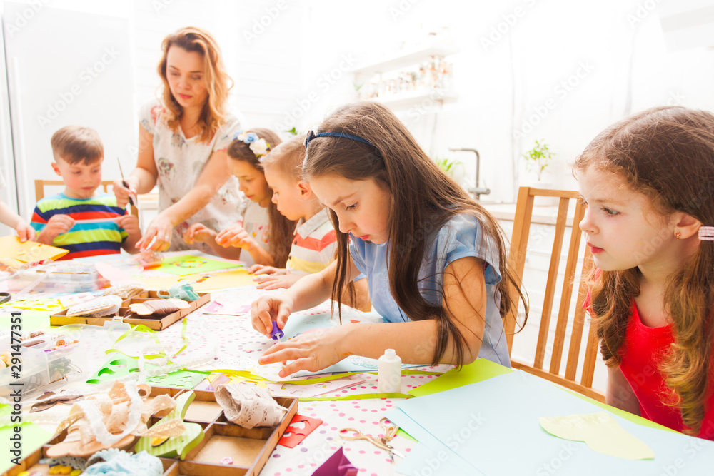 Children do applique work with the help of a teacher