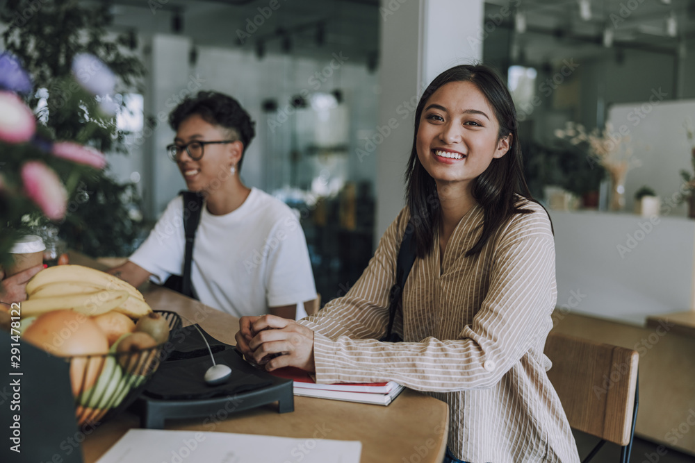 Pretty smiling female student with notebook in cafe Pretty smiling female student with notebook in cafe