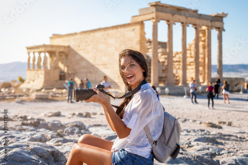 Attraktive Touristin mit Kamera in der Hand besucht die Akropolis von Athen während ihres Städtetrips, Griechenland