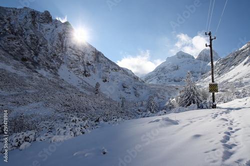 Power lines running through a snow covered mountain landscape © Ivelin
