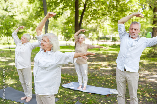 Joyful old people practicing chi kung in the park