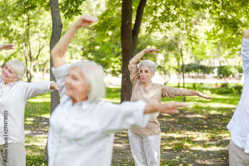 Smiling old women practicing qigong in the park