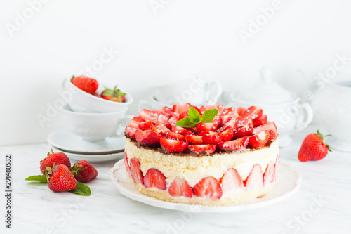 Strawberry cake Fraisier on the white plate and cups