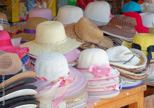 Women's straw hats from the sun of different colors. Many hats from the sun. Beach hats for summer, Design of women's beach hats.