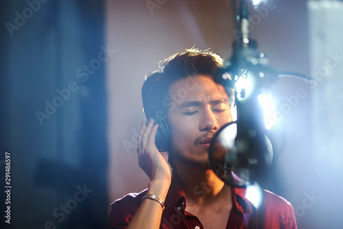 young asian musician recording songs in studio photo